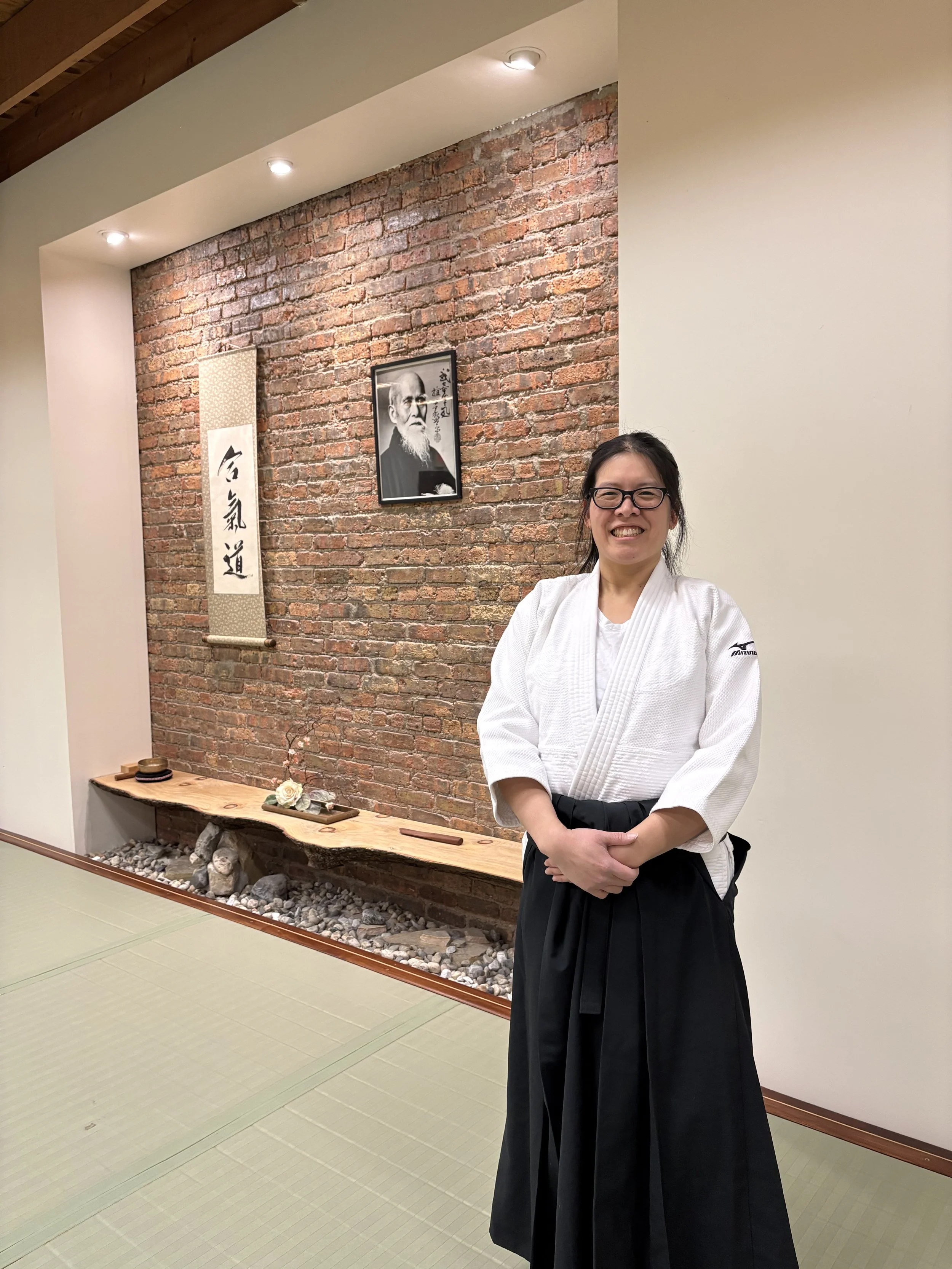 Christine Leung, an aikidoist posing in from of an aikido shomen